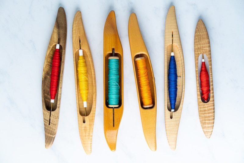 Hand Weaving Academy photo of boat shuttles prepared with many colors.