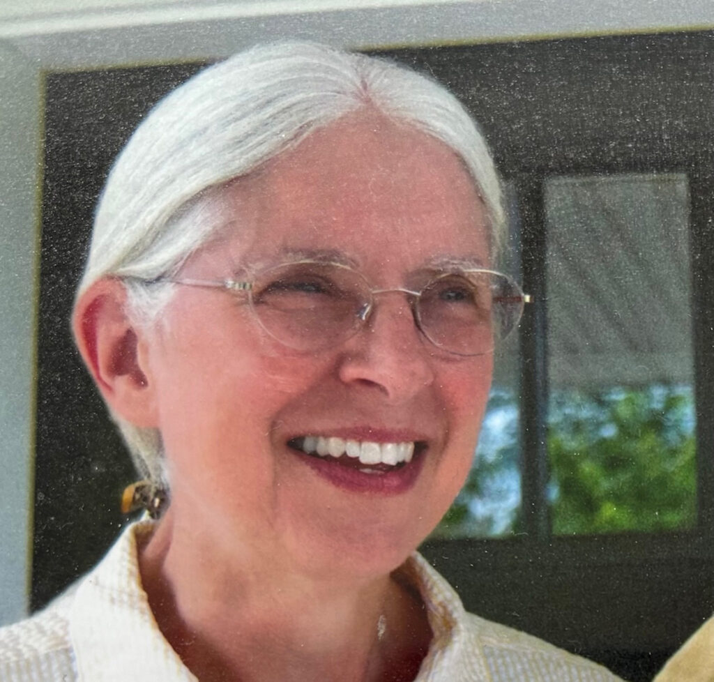 Barb Thoreson smiling, with silver hair pulled back and wire-rimmed glasses