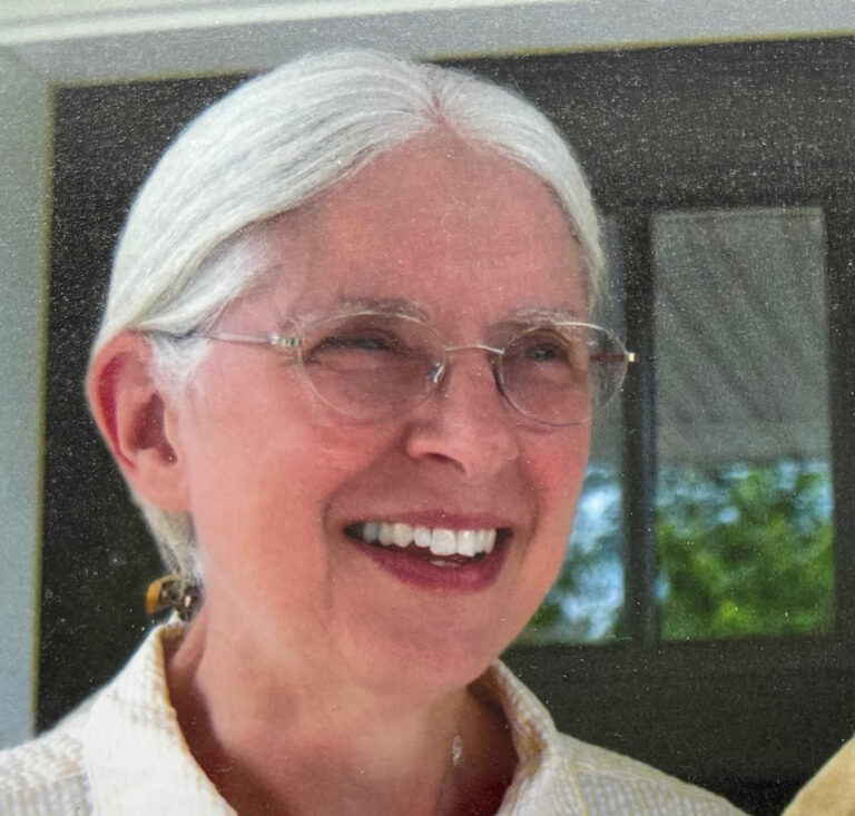 Barb Thoreson smiling, with silver hair pulled back and wire-rimmed glasses